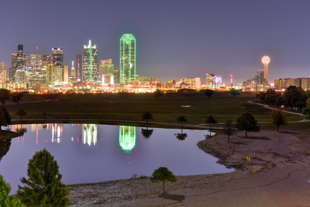 Dallas skyline at night reflected in water, representing DFW as a hub for corporate accounting talent