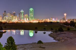 Dallas skyline at night reflected in water, representing DFW as a hub for corporate accounting talent